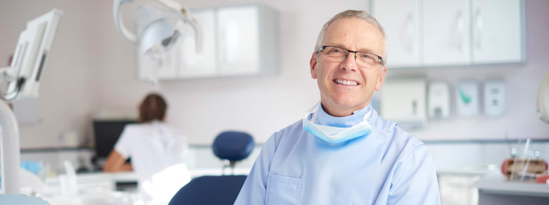 aae-specialty-banner Smiling endodontist in the exam room.